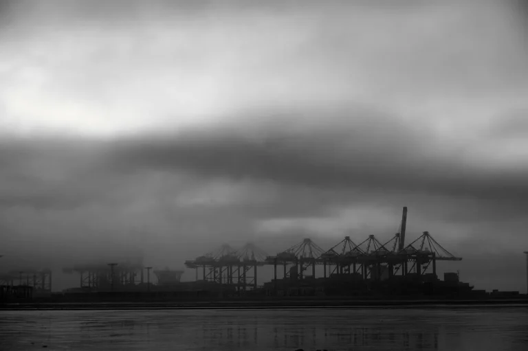 Hafenkräne im Nebel in Schwarz-Weiß: die Reputation einer Reederei
